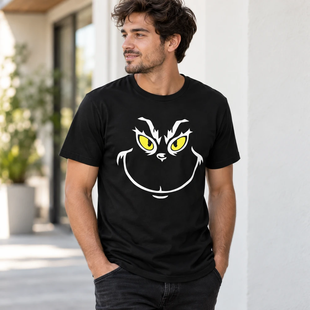 Hombre con camiseta navideña negra con rostro del Grinch en blanco y ojos amarillos.
